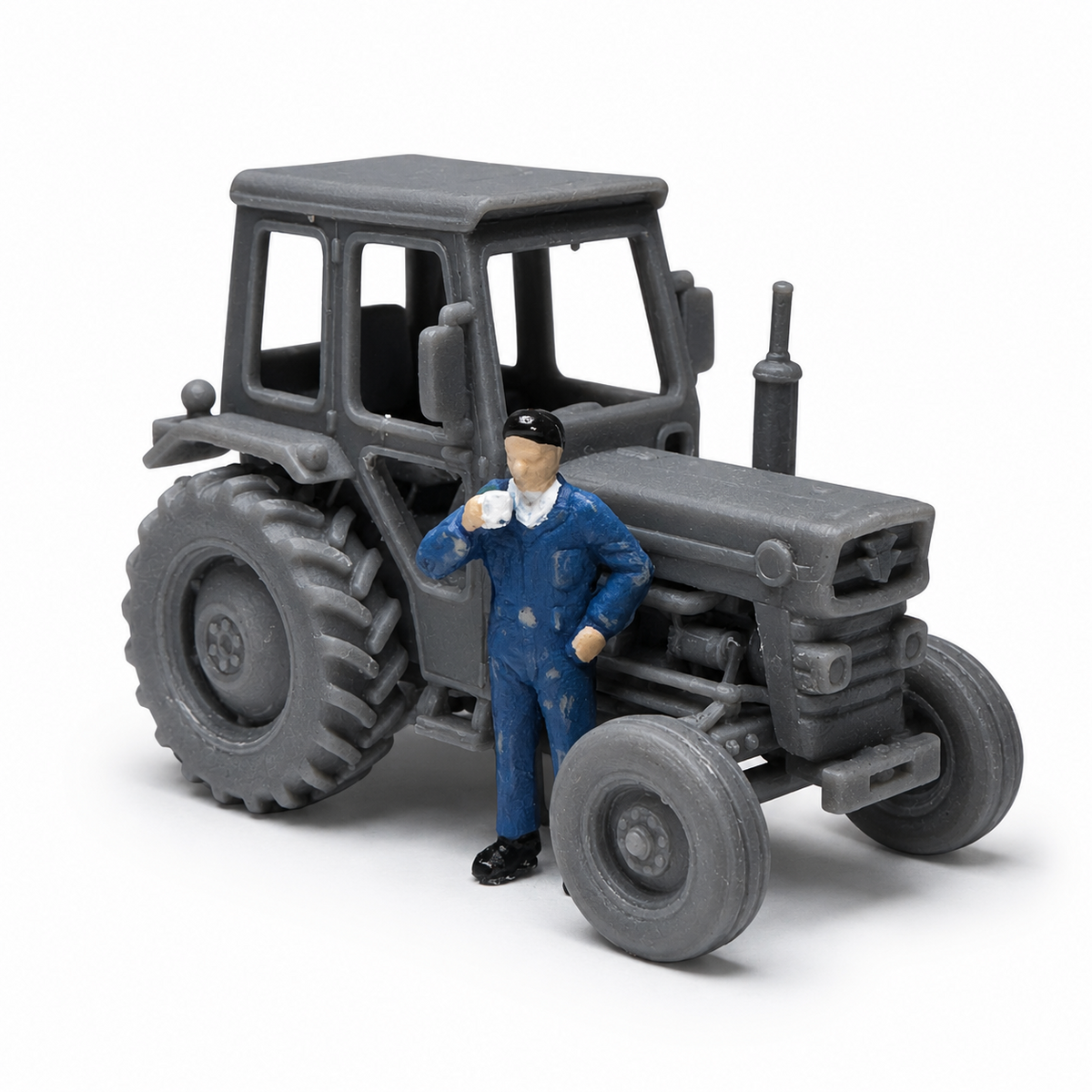 Scale model 1970s Massey Ferguson tractor and small round baler set up for harvest field scenery on a model railway display